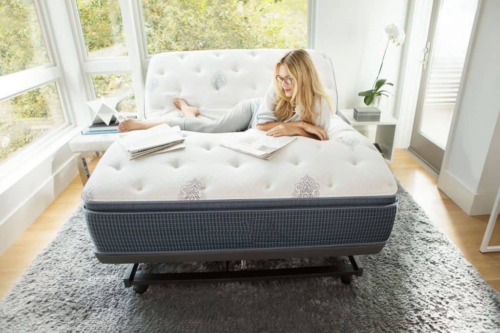 Woman reading a book in one of the best adjustable beds