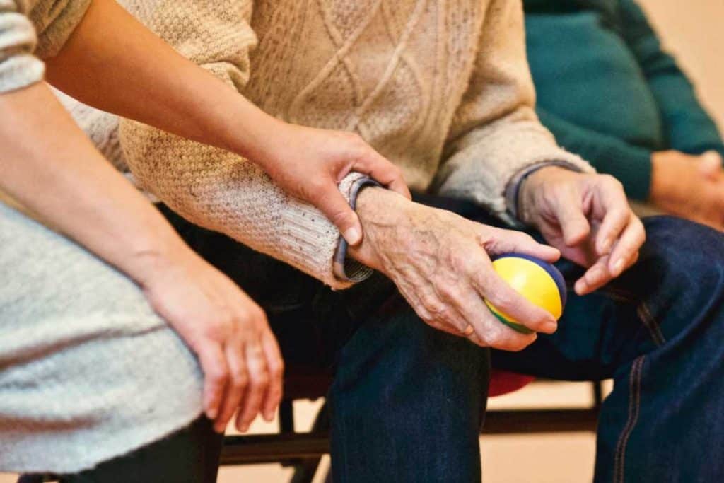 Elderly having alzheimers holding a ball with wife