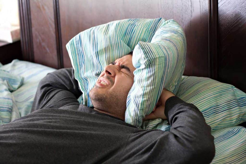 man having trouble sleeping from noise