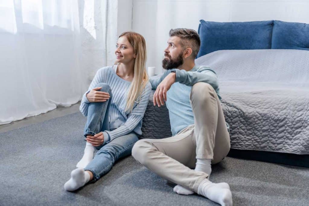 couple sitting on bedroom on darl blue room