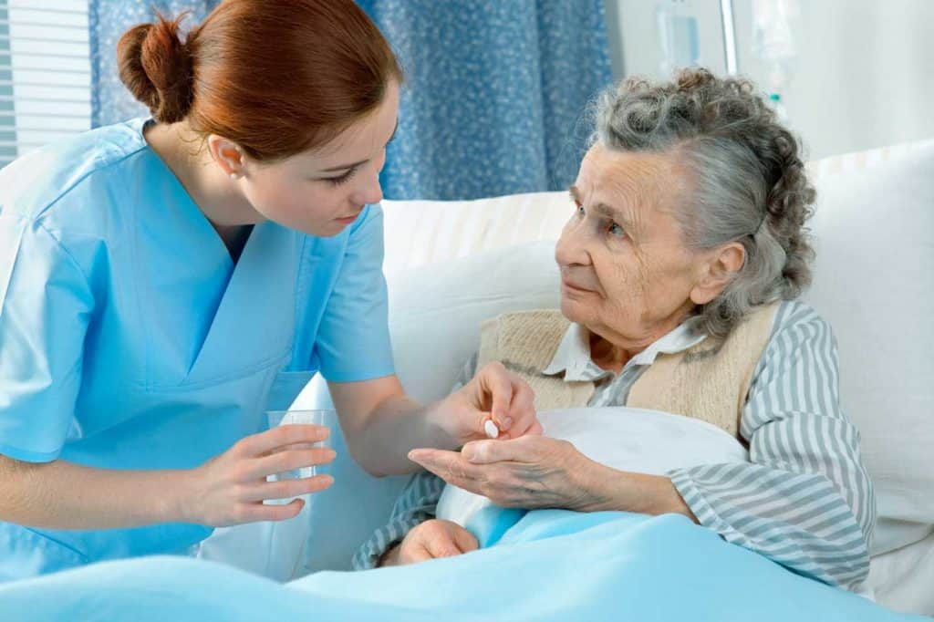 home carer giving medications to elderly