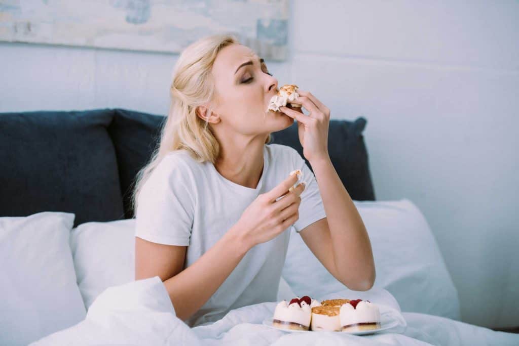 woman eating cake in bed