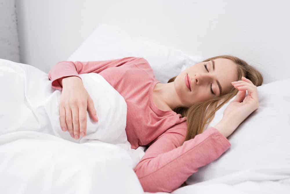 woman sleeping and smiling in bed